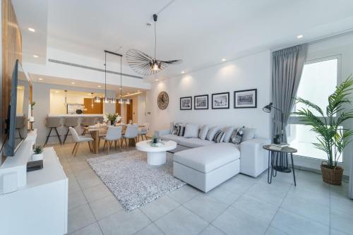 a living room with a couch and a table at StayShort - Stylish Relaxing 3-Bedroom Apartment Perfect for Family in Palm Jumeirah in Dubai