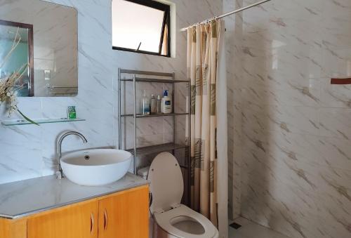 a bathroom with a sink and a toilet and a mirror at Casa Nena Hotel & Resort Iloilo by RedDoorz in Iloilo City