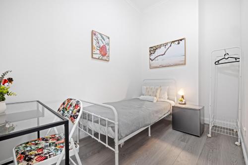a white bedroom with a bed and a glass table at Traditional Single Room - Ideally Located at Kensington - Shared Bathroom in Sydney