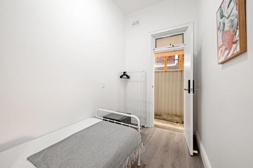 a white room with a bed and a window at Traditional Single Room - Ideally Located at Kensington - Shared Bathroom in Sydney