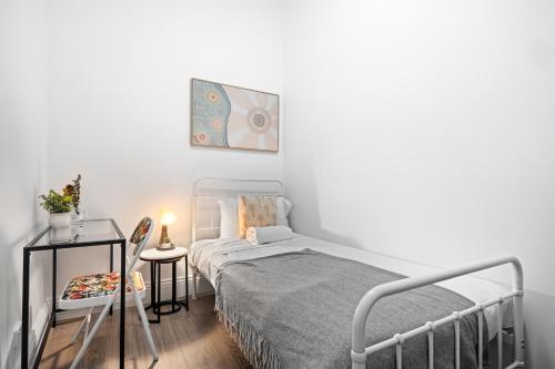 a small bedroom with a bed and a table at Traditional Single Room - Ideally Located at Kensington - Shared Bathroom in Sydney