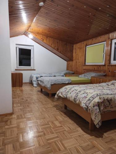 a bedroom with three beds in a room with wooden ceilings at Adam room 1 in Wrocław