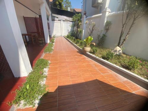 a red brick walkway in a house with plants at Luangprabang Town Pavilion Hotel in Luang Prabang