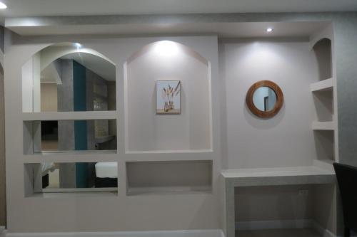 a bathroom with white shelves and a mirror at Baan Bee Residence in Nong Prue