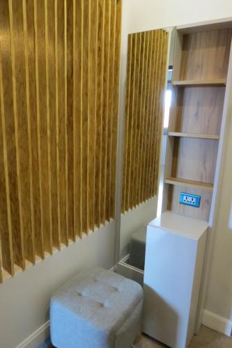 a room with wooden blinds and a white ottoman at Baan Bee Residence in Nong Prue