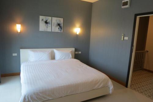 a bedroom with a large white bed with two pillows at Baan Bee Residence in Nong Prue