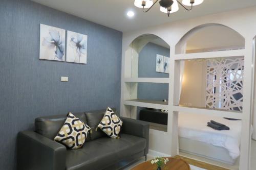 a living room with a couch and a mirror at Baan Bee Residence in Nong Prue