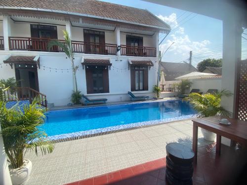 a swimming pool in front of a house at Luangprabang Town Pavilion Hotel in Luang Prabang