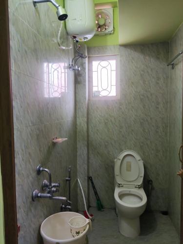 a bathroom with a toilet and a sink at Prashaanti in Guwahati