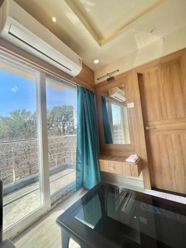 a room with a glass table and a large window at Mountail Eco Resort in Netarhāt