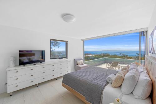 a bedroom with a bed and a large window at Picture Point Terraces in Noosa Heads