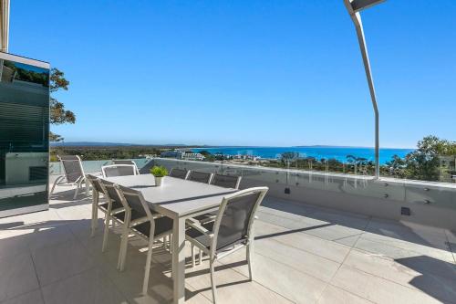 a white table and chairs on a balcony with the ocean at Picture Point Terraces in Noosa Heads