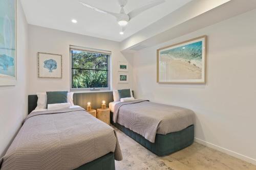 a bedroom with two beds and a window at Picture Point Terraces in Noosa Heads