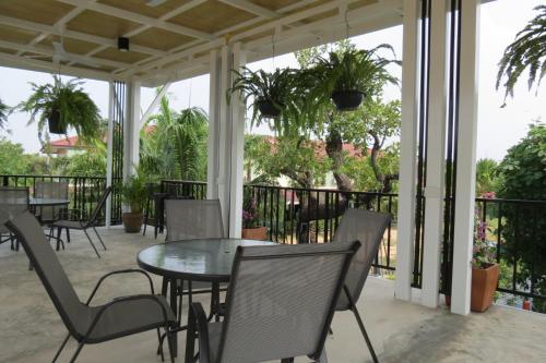 a patio with tables and chairs on a balcony at Baan Bee Residence in Nong Prue