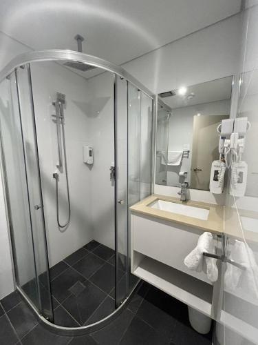 a bathroom with a shower and a sink at Marco Polo Motor Inn Sydney Hotel in Sydney