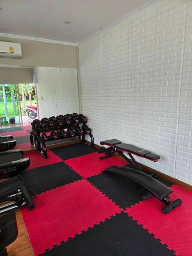 a room with a gym with two treadmills and a red carpet at Baan Bee Residence in Nong Prue