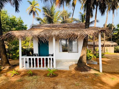 戈卡尔纳The Meraki Beach Resort Gokarna的茅草屋顶的小小屋