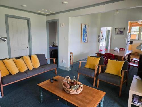 a living room with couches and a table with a basket at Fishermans Cottage in Queenscliff