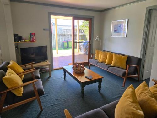 a living room with a couch and a coffee table at Fishermans Cottage in Queenscliff