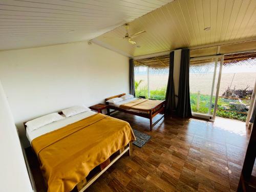 戈卡尔纳The Meraki Beach Resort Gokarna的卧室配有床、桌子和窗户。