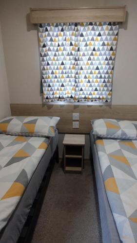 two beds in a small room with a window at Billing Aquadrome, Horizon 3 Bedrooms, BLP 17A in Northampton