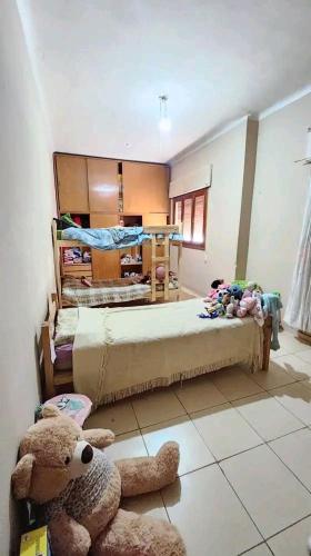 ein Schlafzimmer mit 2 Betten und einem Teddybär auf dem Boden in der Unterkunft Departamento house in Río Cuarto