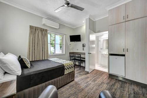 a hotel room with a bed and a kitchen at City Oasis Inn Townsville, SureStay Collection by BW in Townsville