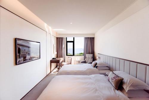 Postel nebo postele na pokoji v ubytování 威海卫大厦 Weihaiwei Hotel