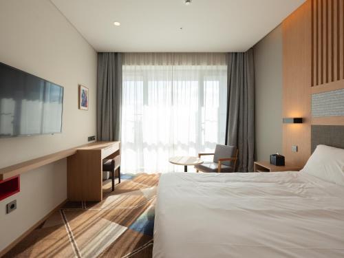 a hotel room with a bed and a desk and a television at Urbanstay Residence Dongtan in Hwaseong