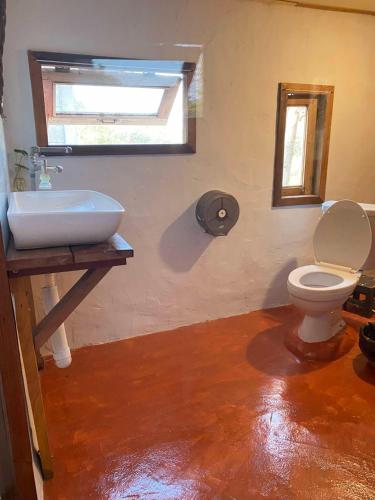 a bathroom with a sink and a toilet and a window at Monsamkien Farmstay in Phayao