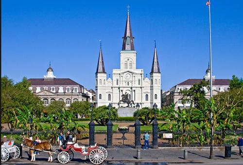 a horse drawn carriage in front of a building at La Galerie French Quarter Hotel in New Orleans