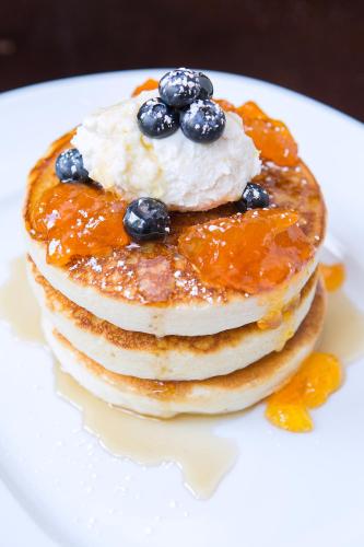 a stack of pancakes with syrup and blueberries on a plate at Four Seasons Hotel Denver in Denver