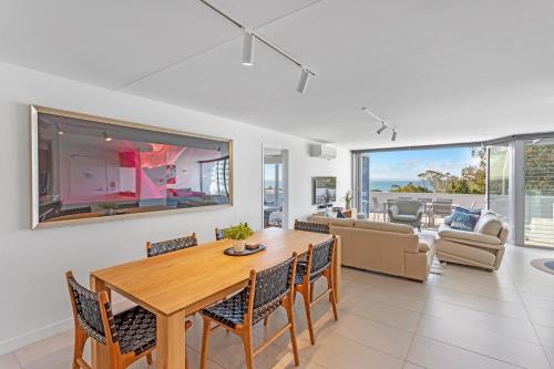 a living room with a wooden table and chairs at Picture Point Terraces in Noosa Heads