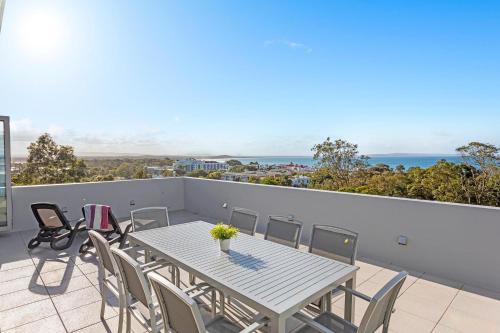 a table and chairs on a balcony with a view of the ocean at Picture Point Terraces in Noosa Heads