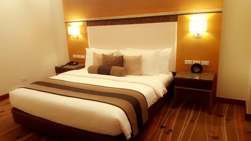 a large bed in a hotel room with two lamps at Best Western Plus The Ivywall Hotel - Palawan in Puerto Princesa City