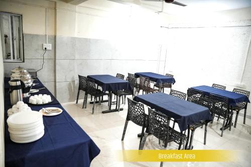 a group of tables and chairs with blue table cloth at My Bizz Hotel Celebration Chakan in Chakan