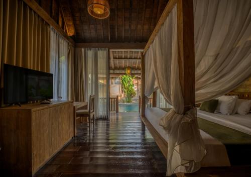 a bedroom with a bed and a television in it at Natajiwa Village in Seminyak