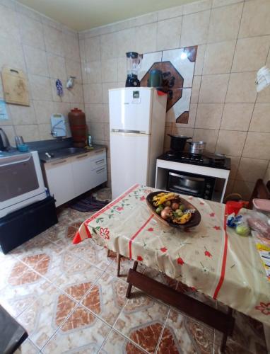 a kitchen with a table with a bowl of fruit on it at Recanto de Sol e Mar SPA in São Pedro da Aldeia