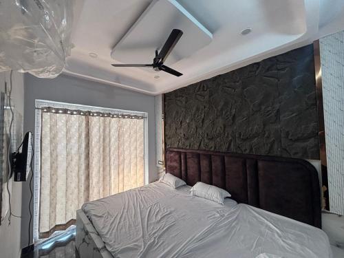 a bedroom with a bed with a ceiling fan at Hotel Radha Madhavam Luxurious Boutique Stay in Mathura
