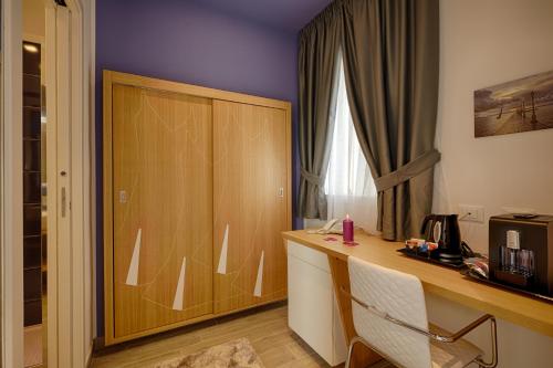a room with a desk and a wooden cabinet at Hospitality Hotel in Palermo