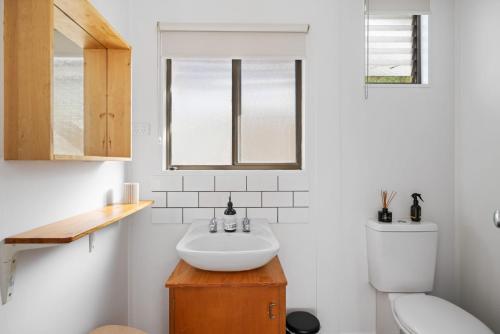 a bathroom with a sink and a toilet at Little Pier Cottage in Inverloch
