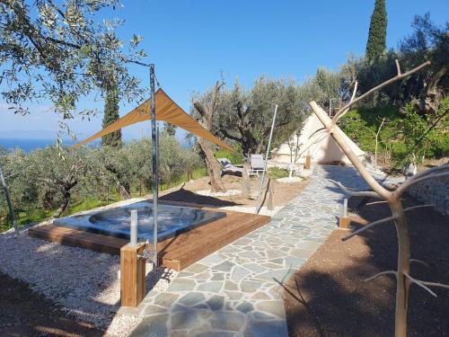 a swimming pool with a tent in a garden at Studios Kyparissi & Spa in Tiros