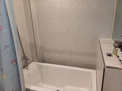 a bathroom with a shower and a white tub at Louis Hotel in Gangneung
