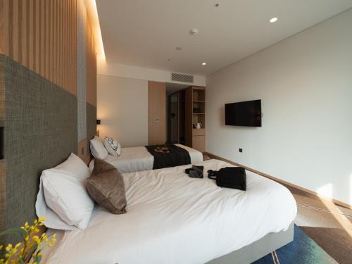 a hotel room with two beds and a television at Urbanstay Residence Dongtan in Hwaseong