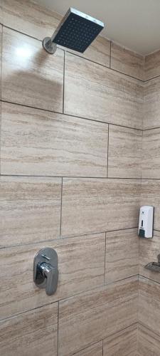a bathroom with a wooden wall with a shower with aaucet at Hotel Alka Inn in Ahmedabad