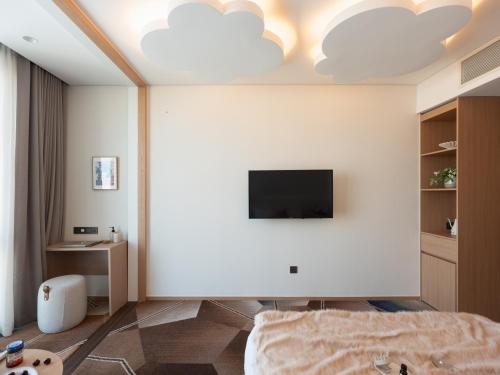 a bedroom with a bed and a tv on the wall at Urbanstay Residence Dongtan in Hwaseong