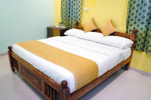 a bedroom with a large wooden bed in a room at Sathya Residency Thandarampet in Tiruvannāmalai