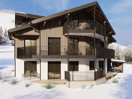 a house in the snow with a balcony at Bergzeit flat Saalbach directly on the ski piste in Saalbach Hinterglemm