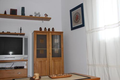 sala de estar con TV y armario de madera en Venecia Bed&Breakfast en Villafranca del Bierzo