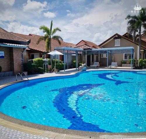 a large blue swimming pool in a house at Rosie Garden & Home in Na Jomtien